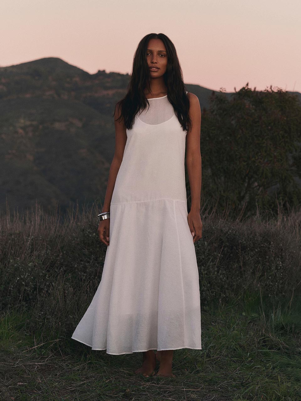 Model posing in a white maxi dress