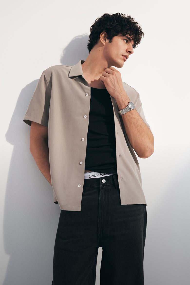 Models posing in an unbuttoned collared short sleeve shirt