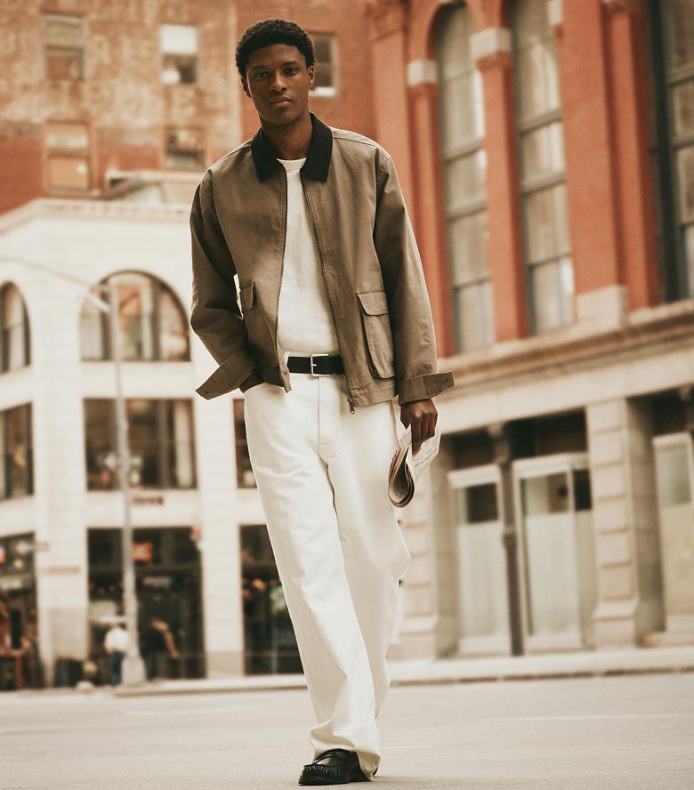 Model posing in a tan canvas jacket