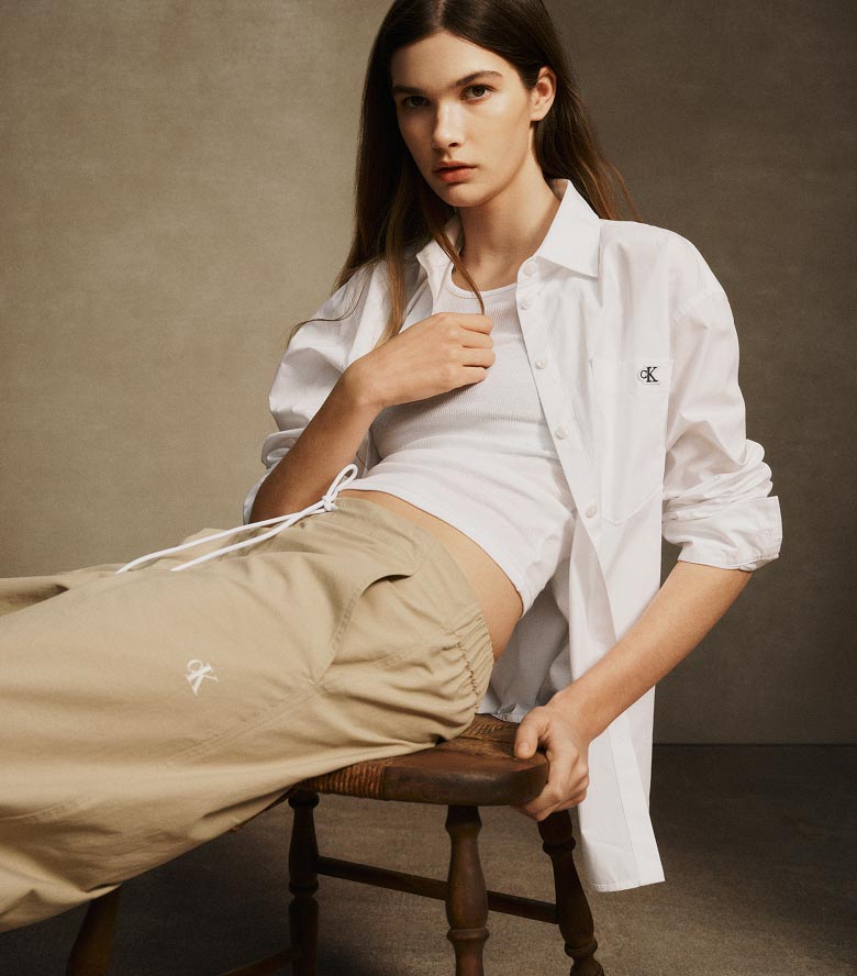 Model posing in tan crinkle nylon pants