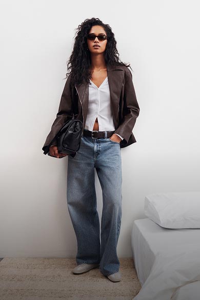 Model posing in medium wash baggy jeans