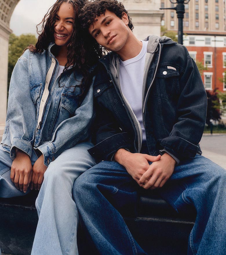 Augie posing in a denim jacket, grey hoodie, white t-shirt, and baggy jeans