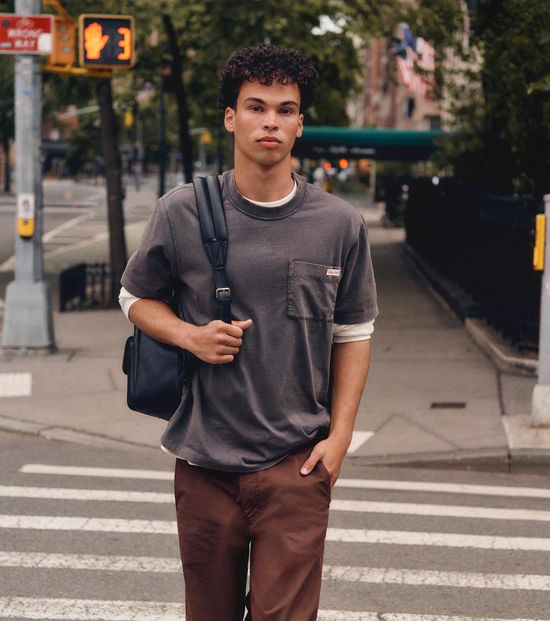 Juan Lucas posing in a grey t-shirt and chinos