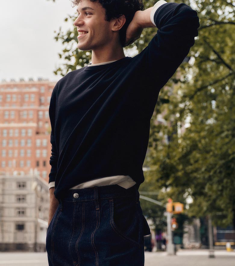 Augie posing in a sweater and baggy utility jeans