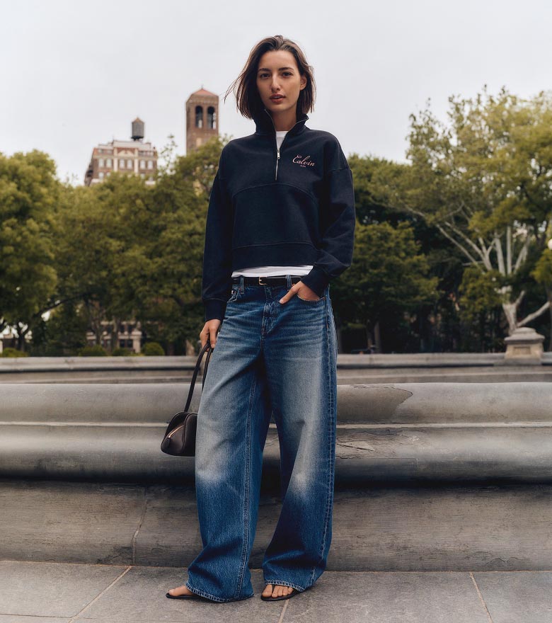 Haena posing in a blue sweatshirt and wide leg jeans