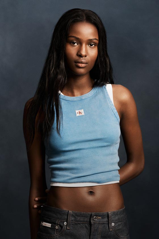 Model posing in a light blue tank top