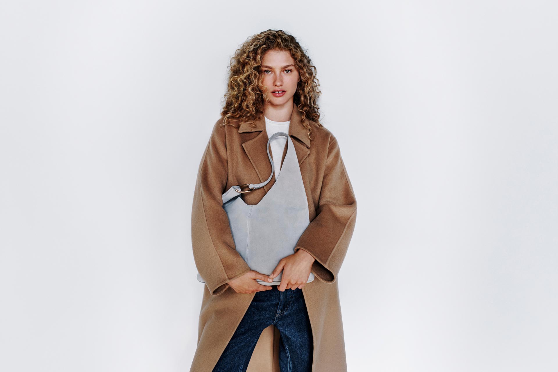 Model posing in a tan wool coat