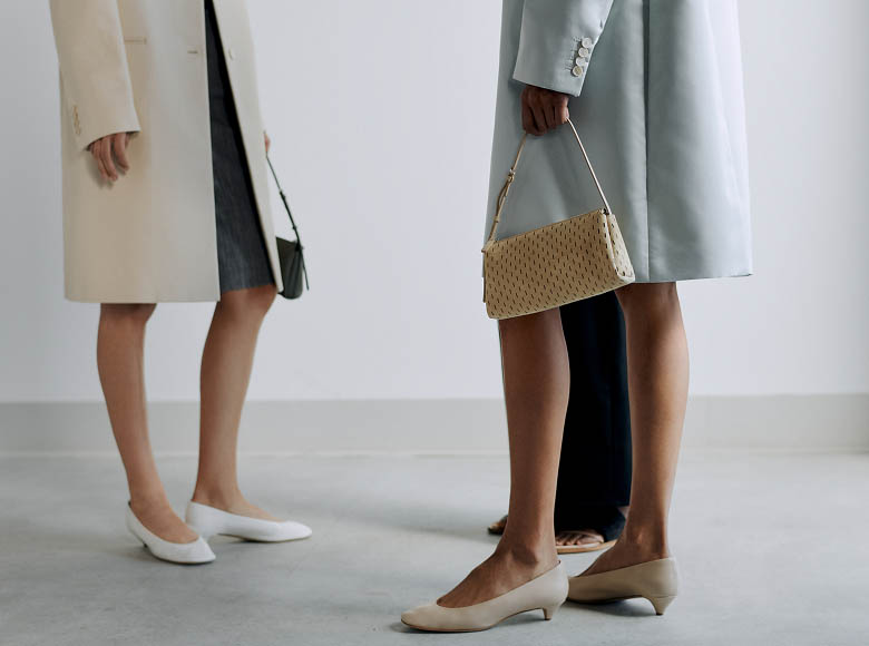 Models carrying handbags backstage