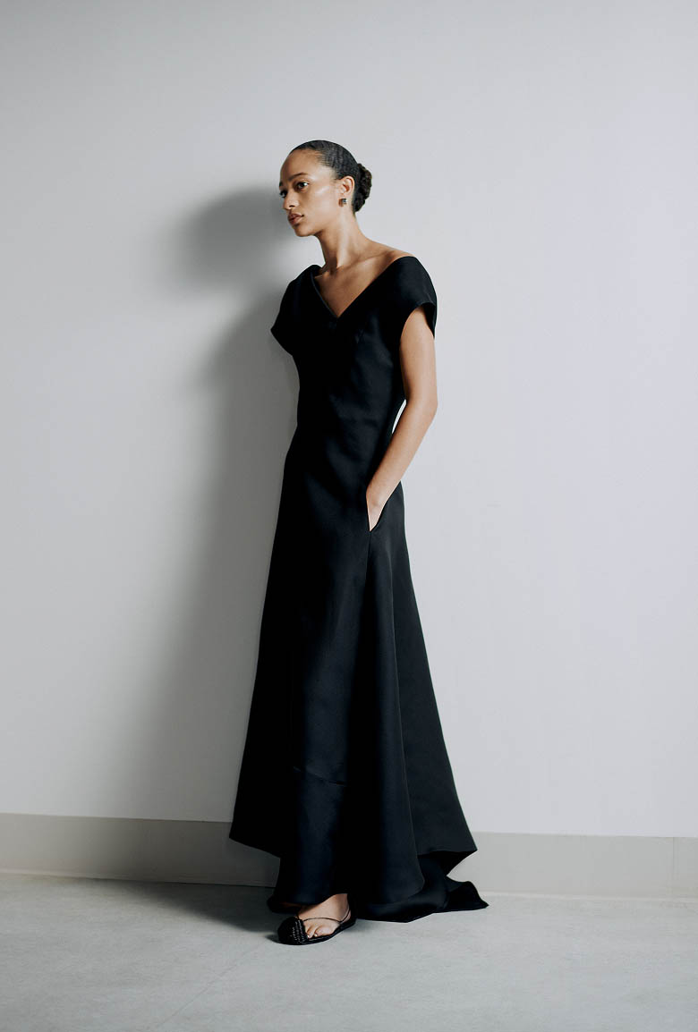 Model wearing a long black dress backstage