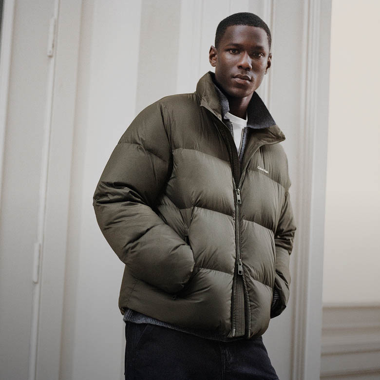 Model posing in a green puffer coat