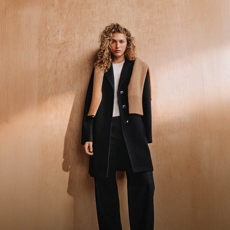 Model posing in a black wool coat