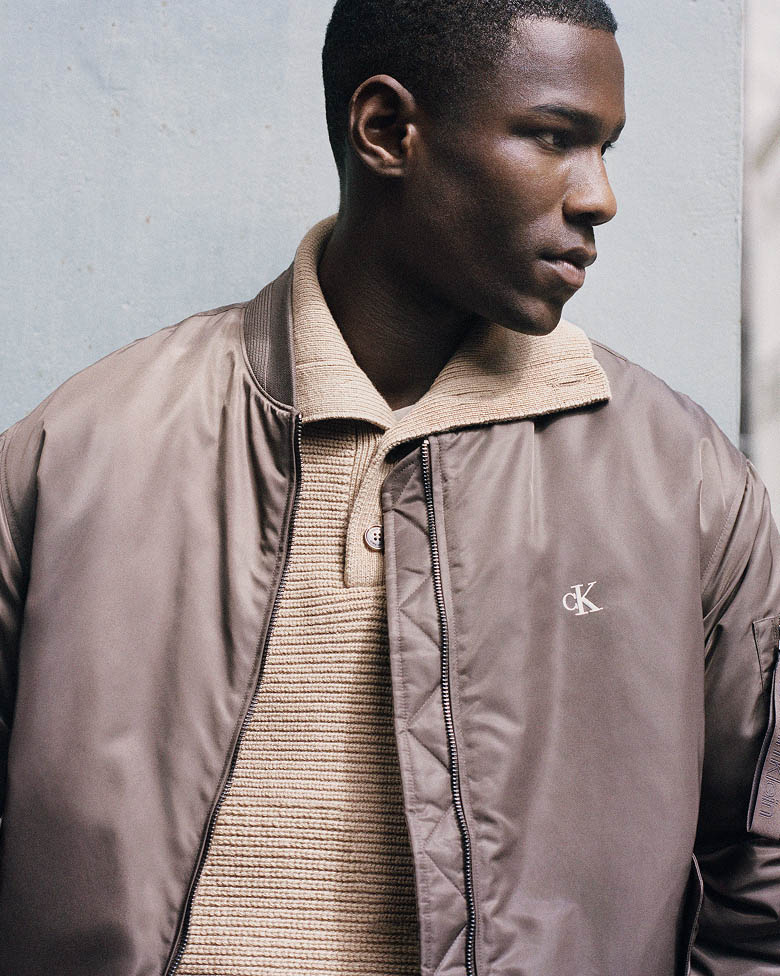 Model posing in a brown bomber jacket