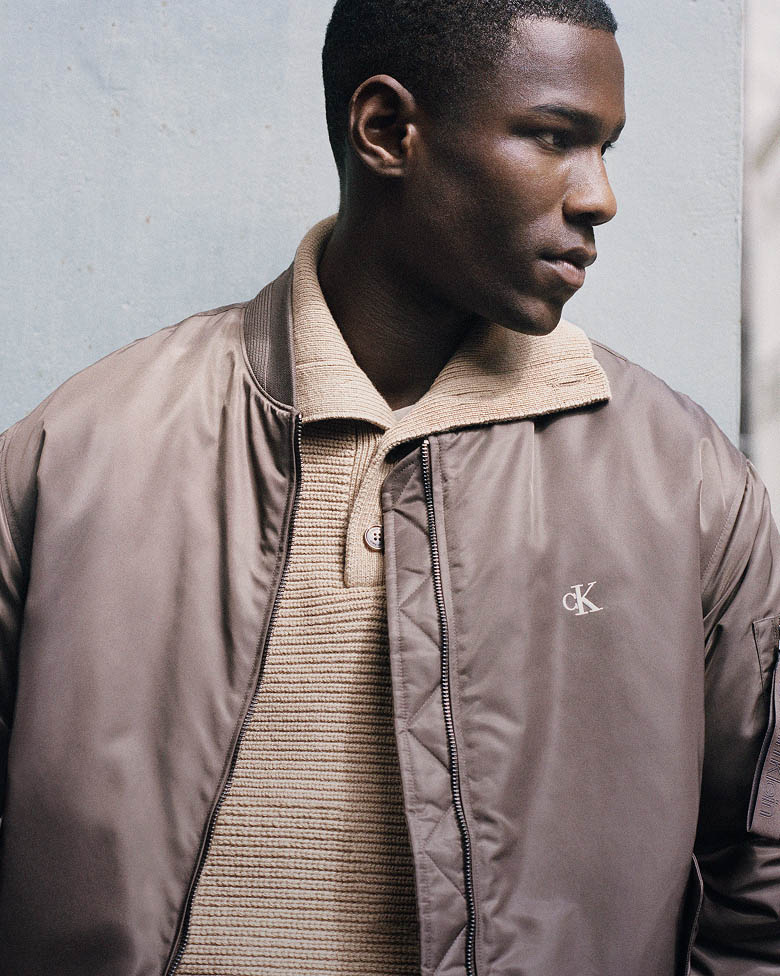 Model posing in brown bomber jacket