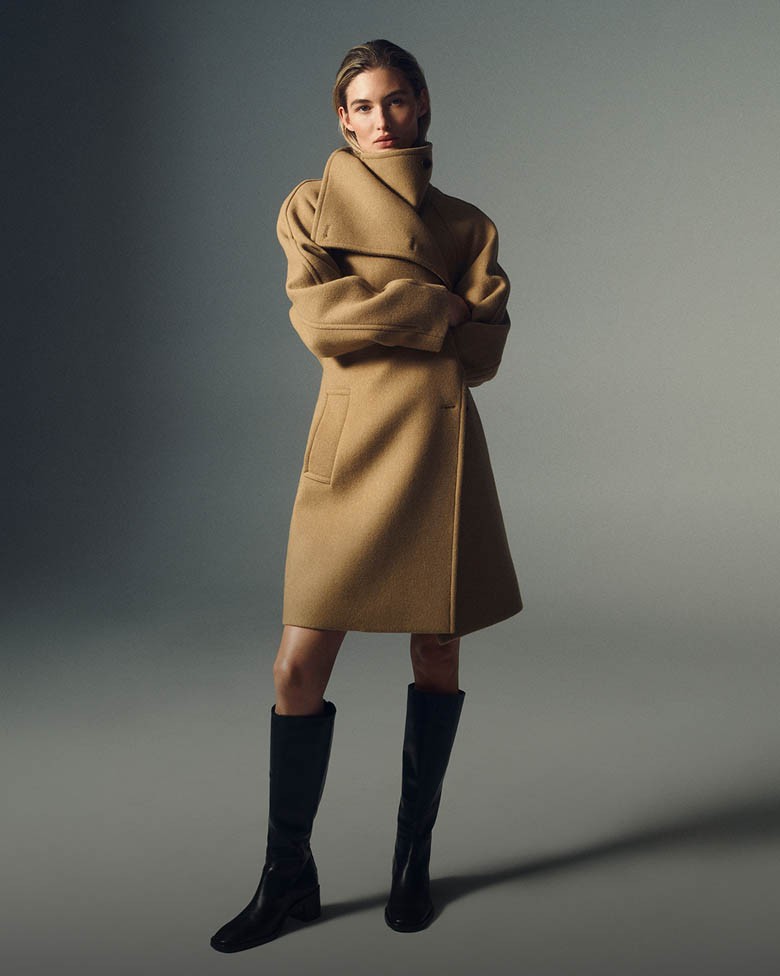 Model posing in tan wrap coat