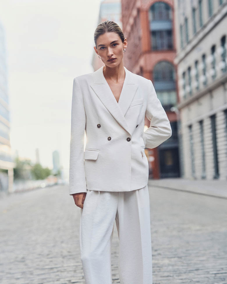 Model posing in white tailored blazer