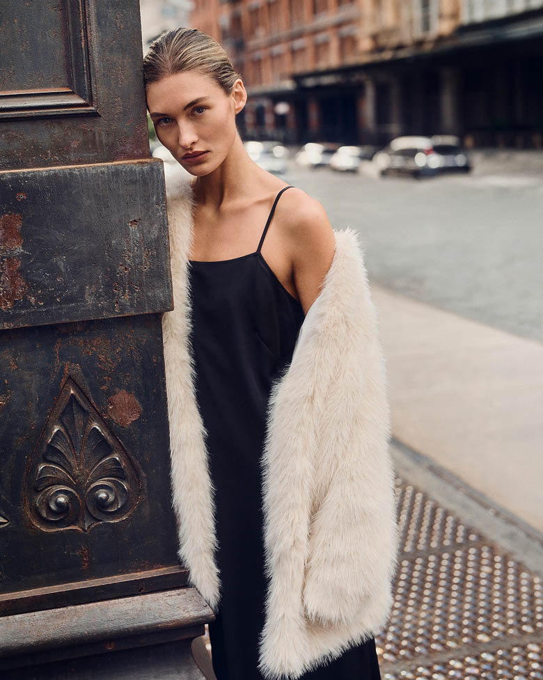 Model posing in a white faux fur coat