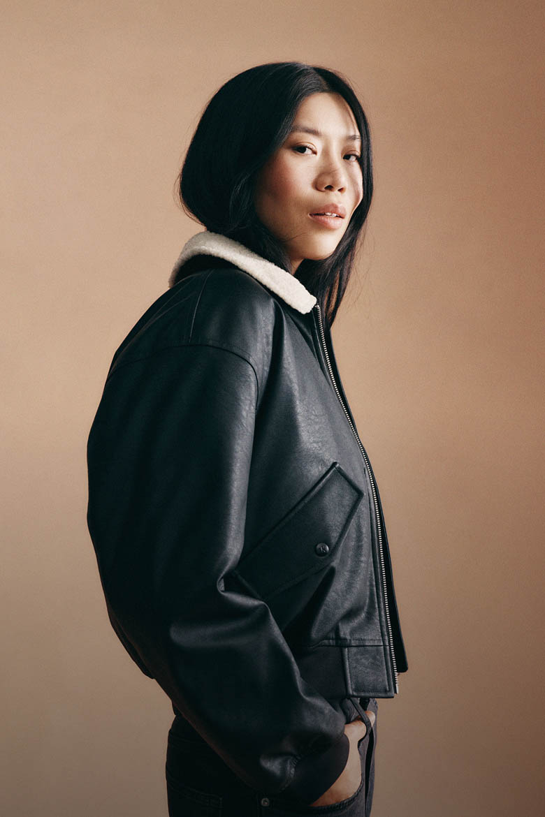 Model posing in a leather bomber jacket