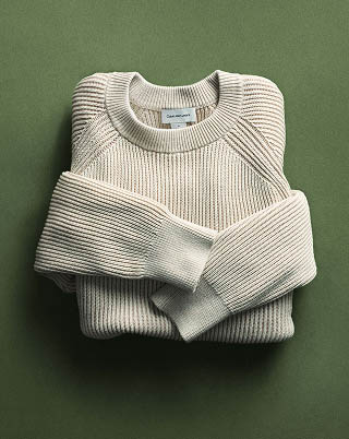 Still life image of a cream textured sweater