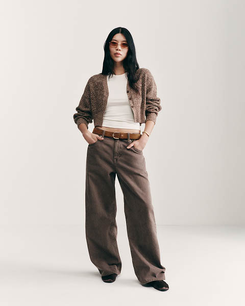 Jessa Choi posing in a white t-shirt, jeans, and a cardigan